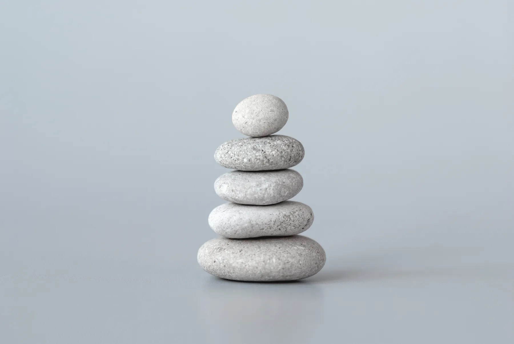 Five pale stones balanced in a measured stack