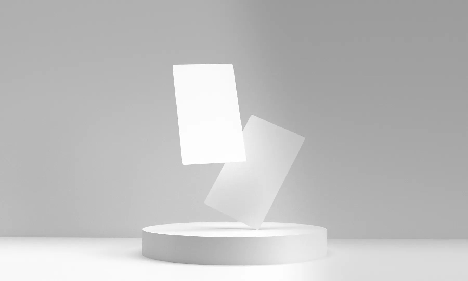 Two blank white cards held in balance above a circular plinth